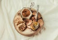 bee pollen in a jar on a wooden stand, Ceylon cinnamon and biscuits, white linen tablecloth background.Copy space.Top view.