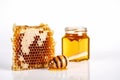 A bee sits on a honeycomb - a jar of honey white background