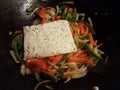 Beef and block of noodles and green and red peppers in frying pan Royalty Free Stock Photo