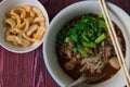 Beef Boat Noodles with Pork Blood Soup, Delicious Asian Style Noodle Serving with Pork Rind on the Wood Table. Royalty Free Stock Photo