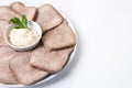 Beef boiled tongue with horseradish on a white plate.