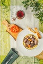 Beef bourguignon in a ceramic plate, tablecloth, fork, flowers Royalty Free Stock Photo