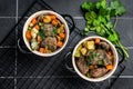 Beef bourguignon meat stew with vegetables, mushrooms and red wine in a pot. Black background. Top view Royalty Free Stock Photo