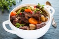 Beef Bourguignon in a white soup bowl on black stone background. Stew with carrots, onions, mushrooms, bacon, garlic and bouquet Royalty Free Stock Photo