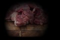 Beef brisket, diced cubed, on a wooden chopping board with a knife. With lighting effect