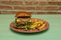 Beef burger with brioche bread, melted Spanish Manchego cheese, cream and lamb\'s lettuce