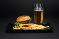 Beef burger with french fries in a black plate Royalty Free Stock Photo