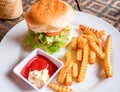 Beef burger with french fries, ketchup and mayonnaise on white plate. Rich nutrititive breakfast. Royalty Free Stock Photo