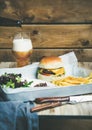 Beef burger, french fries, salad and glass of beer Royalty Free Stock Photo