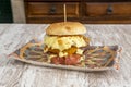 Beef burger with melted cheese of various flavors, fried egg, fried smoked bacon,