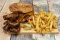 Beef burger menu with crispy onion rings, melted cheddar cheese, side of fries, Royalty Free Stock Photo