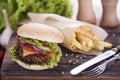 Beef burgers on a wooden board with chips and aromatic spices. Royalty Free Stock Photo