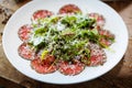 Beef carpaccio. Borettane onion, sun-dried tomato, truffle dressing, arugula salad, parmesan cheese. Italian traditional