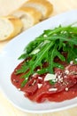 Beef carpaccio with pepper, rucola and parmesan Royalty Free Stock Photo