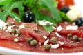 Beef carpaccio with pepper, rucola and parmesan Royalty Free Stock Photo