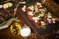 Beef carpaccio with pepper, rucola and parmesan served on a board. Delicious healthy Italian traditional antipasti Royalty Free Stock Photo