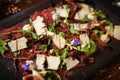 Beef carpaccio with pepper, rucola and parmesan served on a board. Delicious healthy Italian traditional antipasti Royalty Free Stock Photo