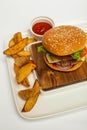 Beef cheeseburger and french fries on wooden table