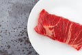 Beef chuck boneless short rib steak on a white plate on a gray counter top Royalty Free Stock Photo