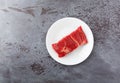 Beef chuck boneless short rib steak on a white plate on a gray counter top