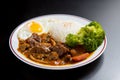 Beef Curry Rice on black wooden background Onsen tamago, Potato, enoki mushroom, onion, broccoli, Japanese style