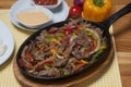 Beef fajitas with colorful bell peppers in pan and sauces Royalty Free Stock Photo