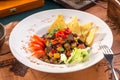 Beef fajitas with colorful vegetables and nachos on old map background