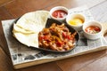 Beef Fajitas with onions and colored pepper, served with tortillas, cheese sauce, salsa and sour cream. Traditional dish of Mexico