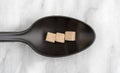 Beef flavored bouillon cubes on a black spoon Royalty Free Stock Photo