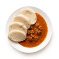 Beef goulash with bread dumplings on white ceramic plate isolated on white. Top view Royalty Free Stock Photo
