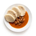 Beef goulash with bread dumplings on white ceramic plate isolated on white. Top view Royalty Free Stock Photo