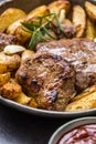 Beef grilled steaks with barbecue sauce roasted potatoes and rosemary Royalty Free Stock Photo