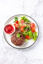 Beef hamburger with lettuce tomato salad on white plate, top view Royalty Free Stock Photo