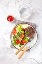 Beef hamburger with lettuce tomato salad on white plate, top view Royalty Free Stock Photo