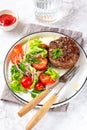 Beef hamburger with lettuce tomato salad on white plate, top view Royalty Free Stock Photo