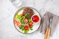 Beef hamburger with lettuce tomato salad on white plate, top view Royalty Free Stock Photo