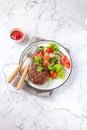 Beef hamburger with lettuce tomato salad on white plate, top view Royalty Free Stock Photo