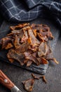 Beef jerky. Dried spiced meat on black table Royalty Free Stock Photo