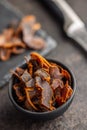 Beef jerky. Dried spiced meat in bowl on black table Royalty Free Stock Photo