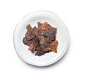 Beef jerky meat on plate. Dried sliced meat isolated on white background