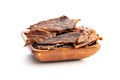 Beef jerky meat in wooden bowl. Dried sliced meat isolated on white background