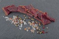 Beef jerky and spice on black stone table. Top view Royalty Free Stock Photo