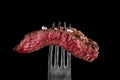 Beef meat rare on fork black background