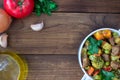 Beef meat stewed with vegetables in ceramic pot with ingredients on wooden background Royalty Free Stock Photo