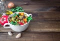 Beef meat stewed with vegetables in ceramic pot with ingredients on wooden background Royalty Free Stock Photo