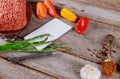 Beef minced with spices and vegetables, colorful peppers and asparagus, notebook, pen on old wood background
