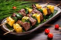 beef and pineapple skewers on a ceramic platter with tropical leaves