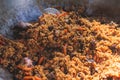 Beef plov, big plate pan of beef fried rice pilaf, cauldron with traditional Central Asia cuisine Uzbek dish with lamb, vegetables