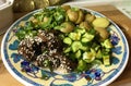 Beef with potatoes and cucumbers on the plate.