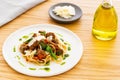 Beef ragout sauce spaghetti pasta with tomatoes, basil and pesto. Aside olive oil, a napkin and parmesan. oak wood. Royalty Free Stock Photo